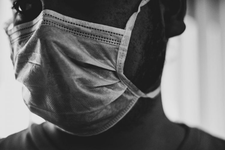 Grocery worker and customer wearing mask to protect from coronavirus spread
